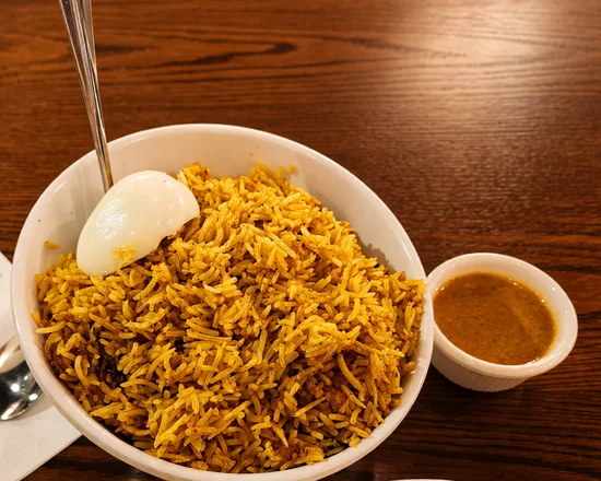 Hyderabadi chicken dum biryani with a boiled egg and a cup of salan at Bawarchi in Mississauga